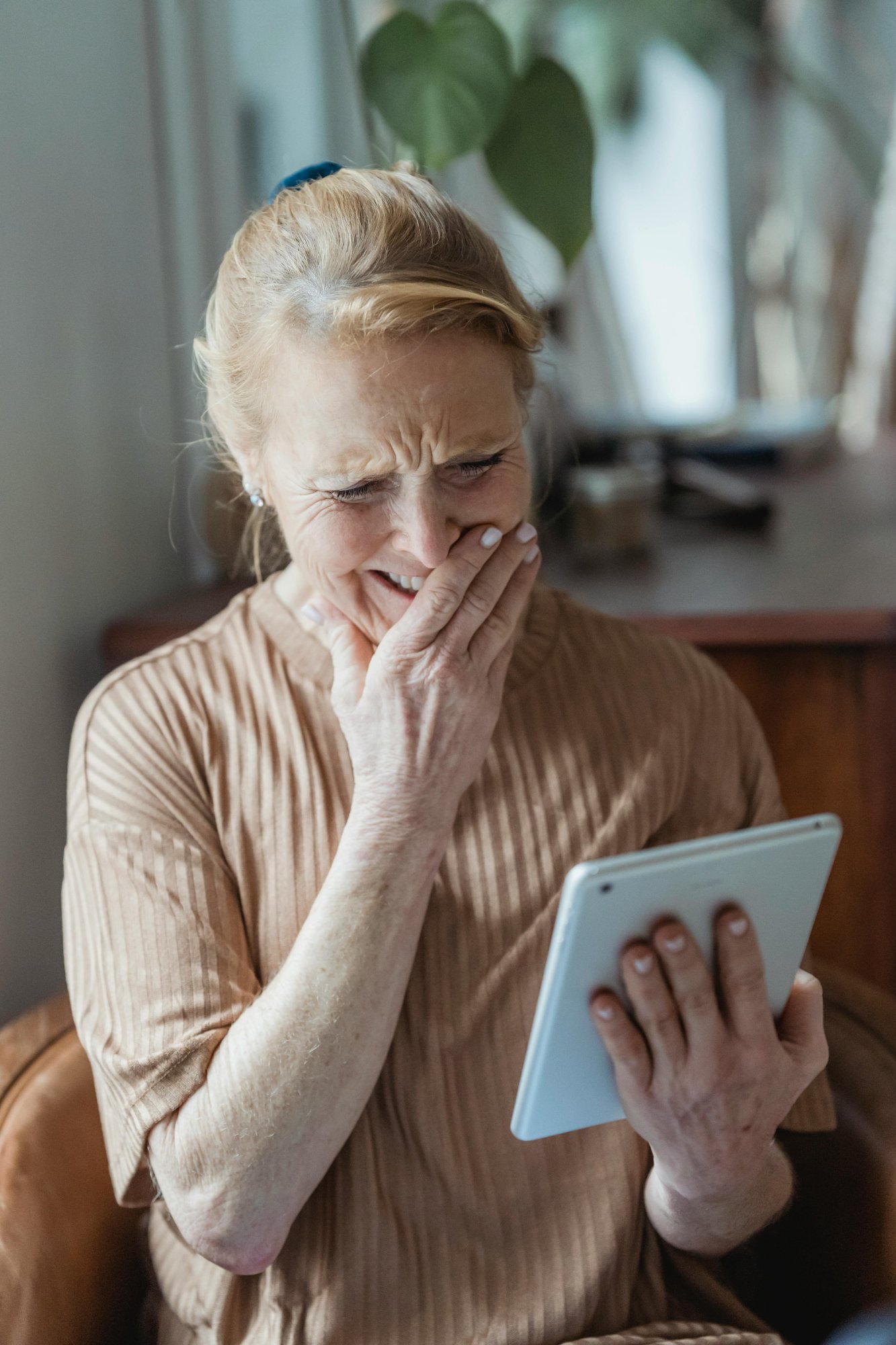 Senior woman laughing during a video call with her companion